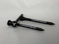 Two black wooden Tomahawk golf tees with white branding, displayed on a light gray background.